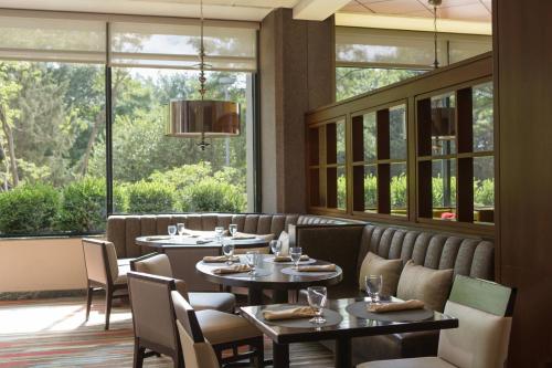 a restaurant with tables and chairs and large windows at Washington Dulles Marriott Suites in Herndon