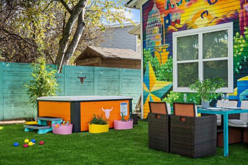 a colorful house with a table and chairs in the yard at Stylish 4BR with Infrared Sauna, Hot Tub, Cornhole and Cowboy Pool in Austin