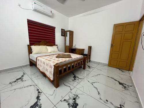 a bedroom with a bed and a red and white wall at Cliff Diaries in Varkala