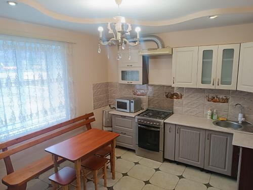 a kitchen with a table and a bench in it at Гірська роса in Verkhniy Yasenov
