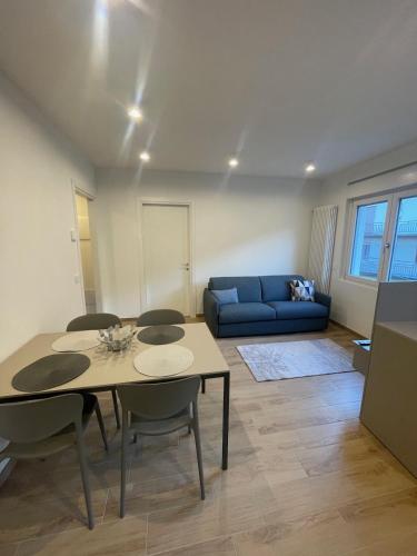 a living room with a table and a blue couch at Cà Marina in Ornavasso