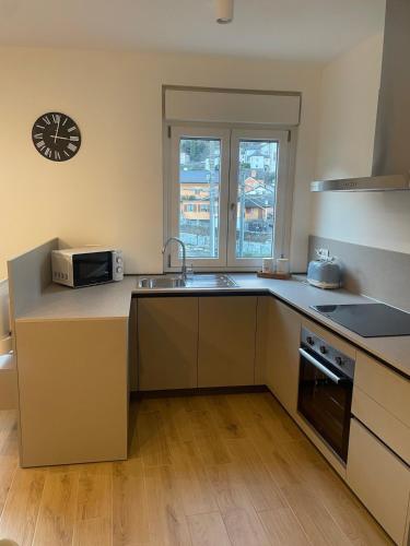 a kitchen with a sink and a microwave at Cà Marina in Ornavasso