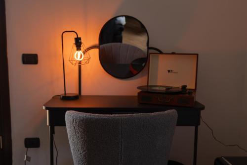 a desk with a lamp and a mirror on it at V&V art & rooms in Nocera Inferiore