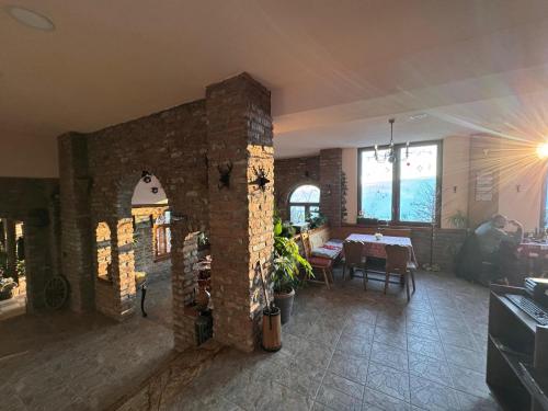 a living room with a table and a brick wall at Casa Leone Hotel&Restaurant in Popova Shapka