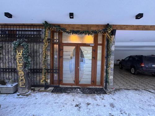 a front door of a house with christmas garland at Casa Leone Hotel&Restaurant in Popova Shapka