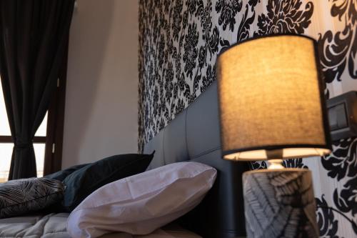 a lamp sitting next to a bed in a room at V&V art & rooms in Nocera Inferiore