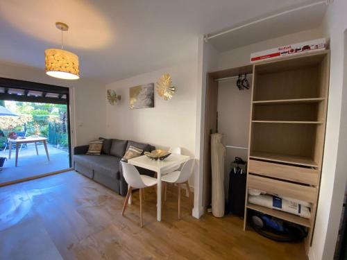 un salon avec un canapé et une table dans l'établissement Les jardins de la mer - Calme - Terrasse - Parking - 200m de la mer, aux Lecques