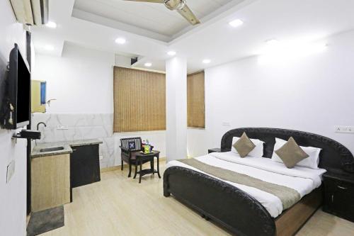a bedroom with a bed and a desk and a television at Hotel O The Premium Villla in New Delhi