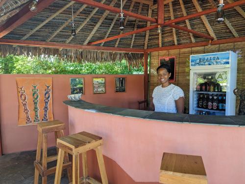 a woman standing behind a counter at a bar at Hotel Lakana Ramena in Diego Suarez