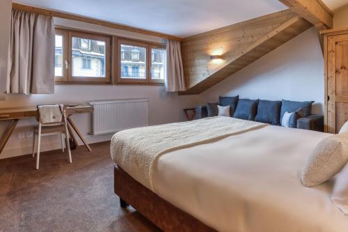 a bedroom with a large bed and a desk at Hôtel Lyret in Chamonix-Mont-Blanc