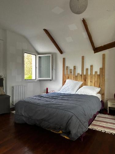 une chambre avec un grand lit et une fenêtre dans l'établissement MAISON à 100 METRES DE LA PLAGE, à Pléneuf-Val-André