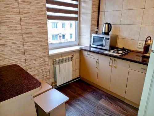 a small kitchen with a stove and a microwave at Apart Perspektivna in Kropyvnytskyi