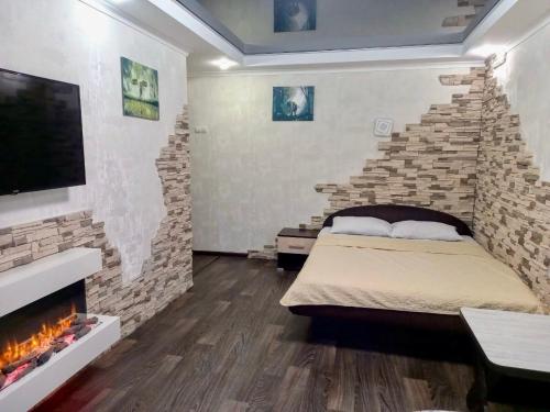 a bedroom with a brick wall with a bed and a fireplace at Apart Perspektivna in Kropyvnytskyi