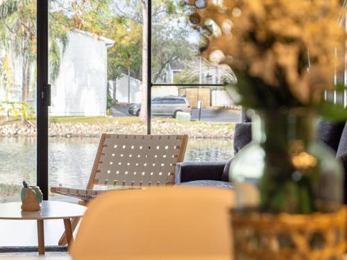 a room with chairs and a table with a vase of flowers at Busch Gardens TownhouseUSF & Mofitt in Tampa