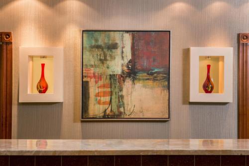 three red vases on a wall with a painting at Residence Inn Dulles Airport At Dulles 28 Centre in Sterling