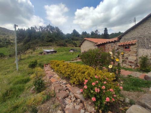 a garden with flowers in front of a building at Casa de campo Namasté in Sutatausa