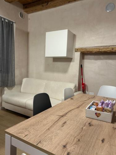 a living room with a table and a couch at Larocca Tourist Home 1 Valbrenta in Carpane