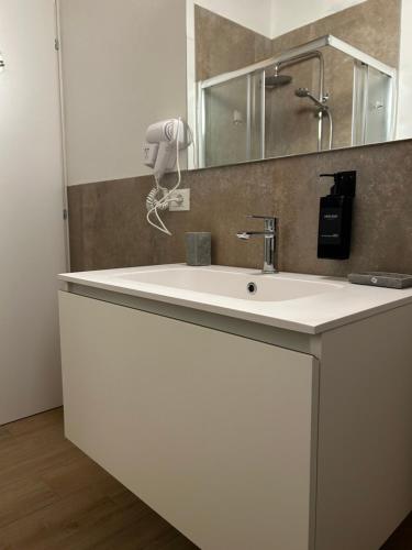 a bathroom with a white sink and a mirror at Larocca Tourist Home 1 Valbrenta in Carpane