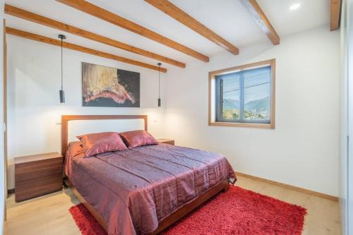 Schlafzimmer mit einem Bett mit einem roten Teppich und einem Fenster in der Unterkunft Casa Oliveira Gêres in Terras de Bouro