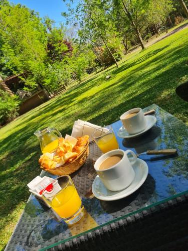ein Picknicktisch mit zwei Tassen Kaffee und Brot in der Unterkunft Portal del Río Posada in Santa Rosa de Calamuchita