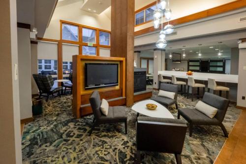 ein Wohnzimmer mit Fernseher und Tisch und Stühlen in der Unterkunft Residence Inn by Marriott Hazleton in Hazleton