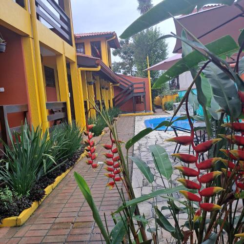 a building with a bunch of red flowers in a courtyard at Pousada Trilha da Serra in Morretes