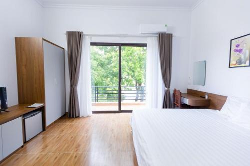 a bedroom with a bed and a sliding glass door at Tam coc Newway Homestay in Ninh Binh