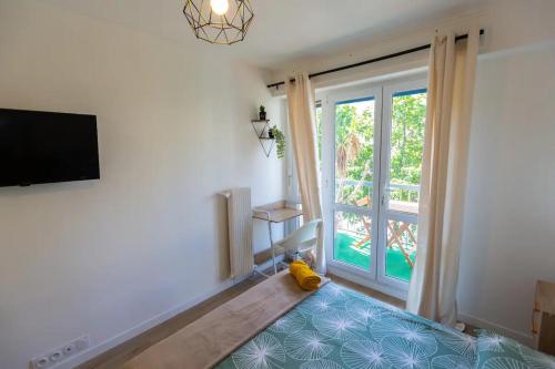 un salon avec une télévision et une grande fenêtre dans l'établissement T5 Idéal Groupes & Familles, St Charles-Joliette, à Marseille