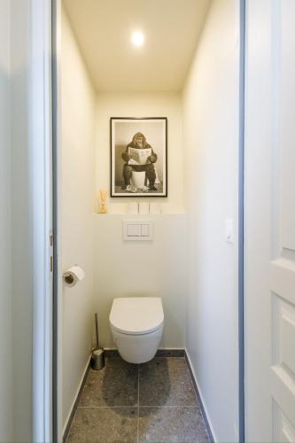 une salle de bain avec toilettes et un tableau au mur dans l'établissement Lovely Duplex, à Trouville-sur-Mer