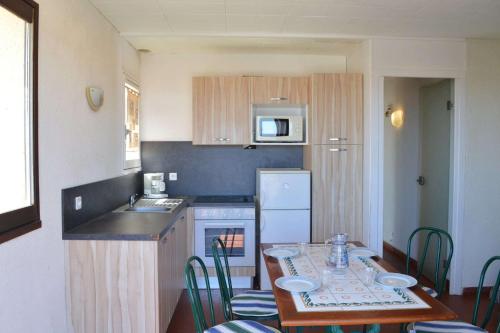 une petite cuisine avec une table, des chaises et un évier dans l'établissement SP930-004 Appartement 3 pièces 4 couchages SAINT PIERRE LA MER, à Saint Pierre La Mer
