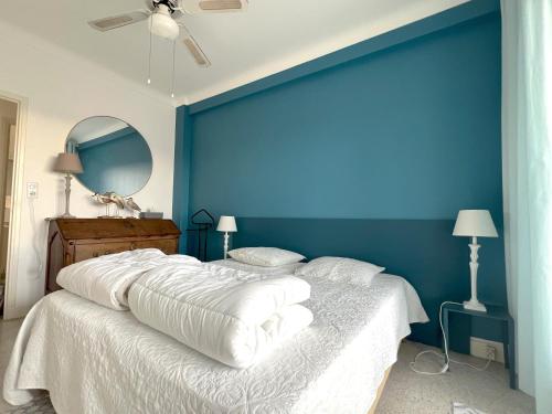 - une chambre avec un mur bleu et un grand lit dans l'établissement Terrace and view on all Nice city, à Nice