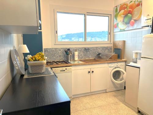 une cuisine avec un évier et une machine à laver dans l'établissement Terrace and view on all Nice city, à Nice