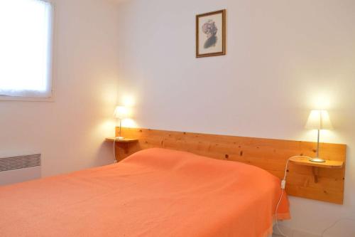 - une chambre avec un lit orange et deux lampes dans l'établissement SP740-117 Maison 3 pièces mezzanine SAINT PIERRE LA MER, à Saint Pierre La Mer