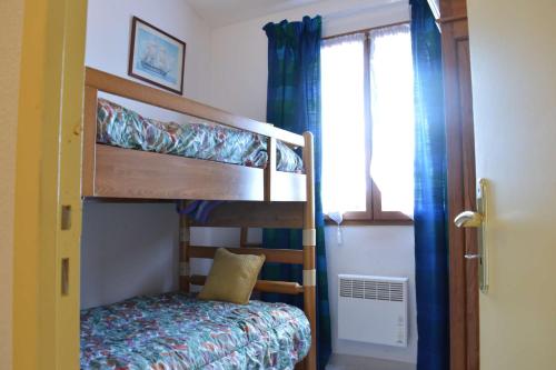une chambre avec deux lits superposés et une fenêtre dans l'établissement SP720-010 Maison 4 pièces SAINT PIERRE LA MER, à Saint Pierre La Mer