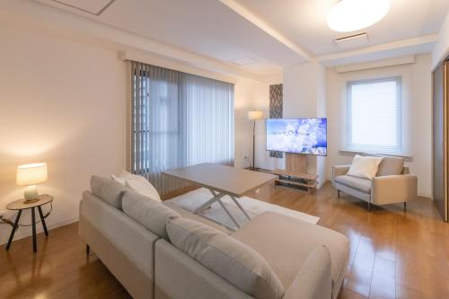 a living room with a couch and a table at Atrium Deluxe Apartments Osaka - Self Check-In Only in Osaka