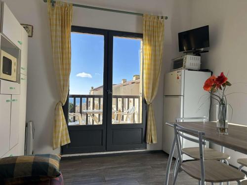 Il comprend une cuisine équipée d'une table et d'un réfrigérateur. dans l'établissement SP690-045 Studio Cabine 4 couchages SAINT PIERRE LA MER, à Saint Pierre La Mer