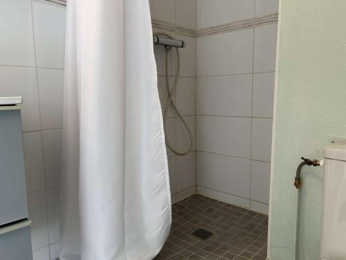 La salle de bains est pourvue d'une douche avec un rideau de douche blanc. dans l'établissement SP570-391 Appartement 2 pièces ST PIERRE LA MER, à Saint Pierre La Mer