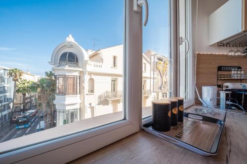 a room with a window with a view of a city at Le Cosy Perpignan Centre, 2 rooms, 2 bathrooms, free WIFI, free parking, lift, central, renovated, spacious in Perpignan