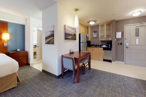 a room with a desk and a kitchen with a bed at Residence Inn San Diego Del Mar in San Diego