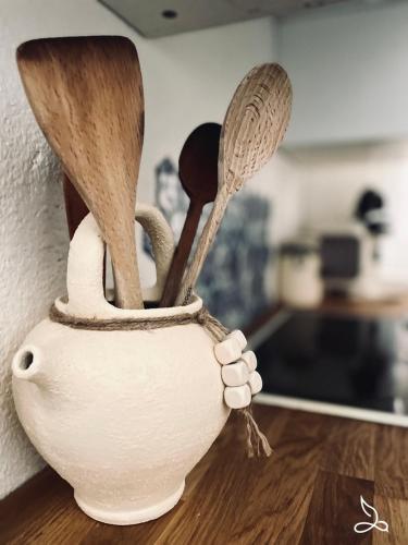 un vase blanc rempli d'ustensiles de cuisine en bois dans l'établissement Appart rdc 6pers-piscine-parking, à Fitou