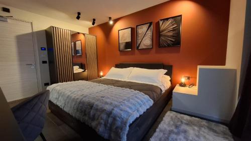 a bedroom with an orange wall with a bed at Hotel La Thuile Resort & SPA in La Thuile