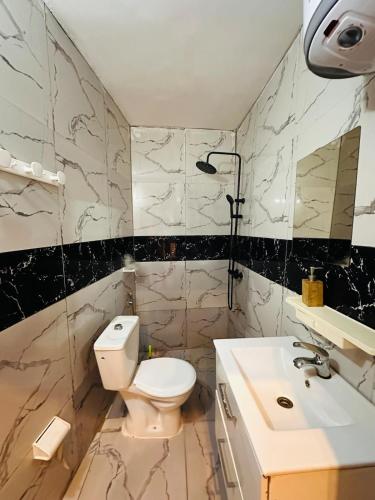 a bathroom with a toilet and a sink at Villa So queen avec piscine in Bamako