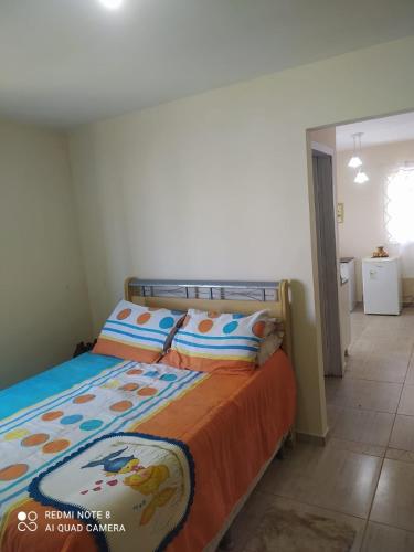 a bedroom with a bed with an orange blanket at Casa a 2 quadras do mar reformada in Matinhos