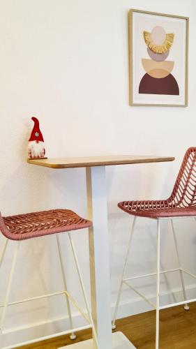 - un bureau avec 2 chaises et une photo sur le mur dans l'établissement Le Studio des Arceaux, à Montpellier
