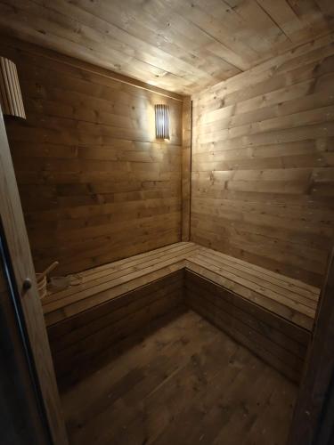 an empty wooden sauna with a light in the corner at Hotel La Thuile Resort & SPA in La Thuile