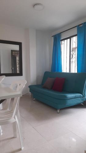 a living room with a green couch and a table at Apartamento completo medellin in Medellín