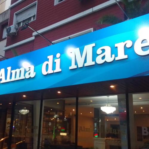 a store with a blue sign on the side of a building at Hotel Alma di Mare in Mar del Plata