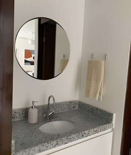 a bathroom with a sink and a mirror at Espetacular Flat em Miramar in João Pessoa