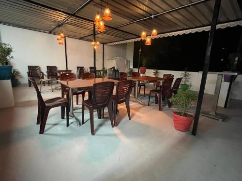 a restaurant with wooden tables and chairs on a patio at BanyanThree in Kodaikānāl