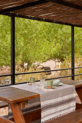 a table with plates and cups on top at La Quebrada Potrerillos - Lodges de Montaña in Potrerillos